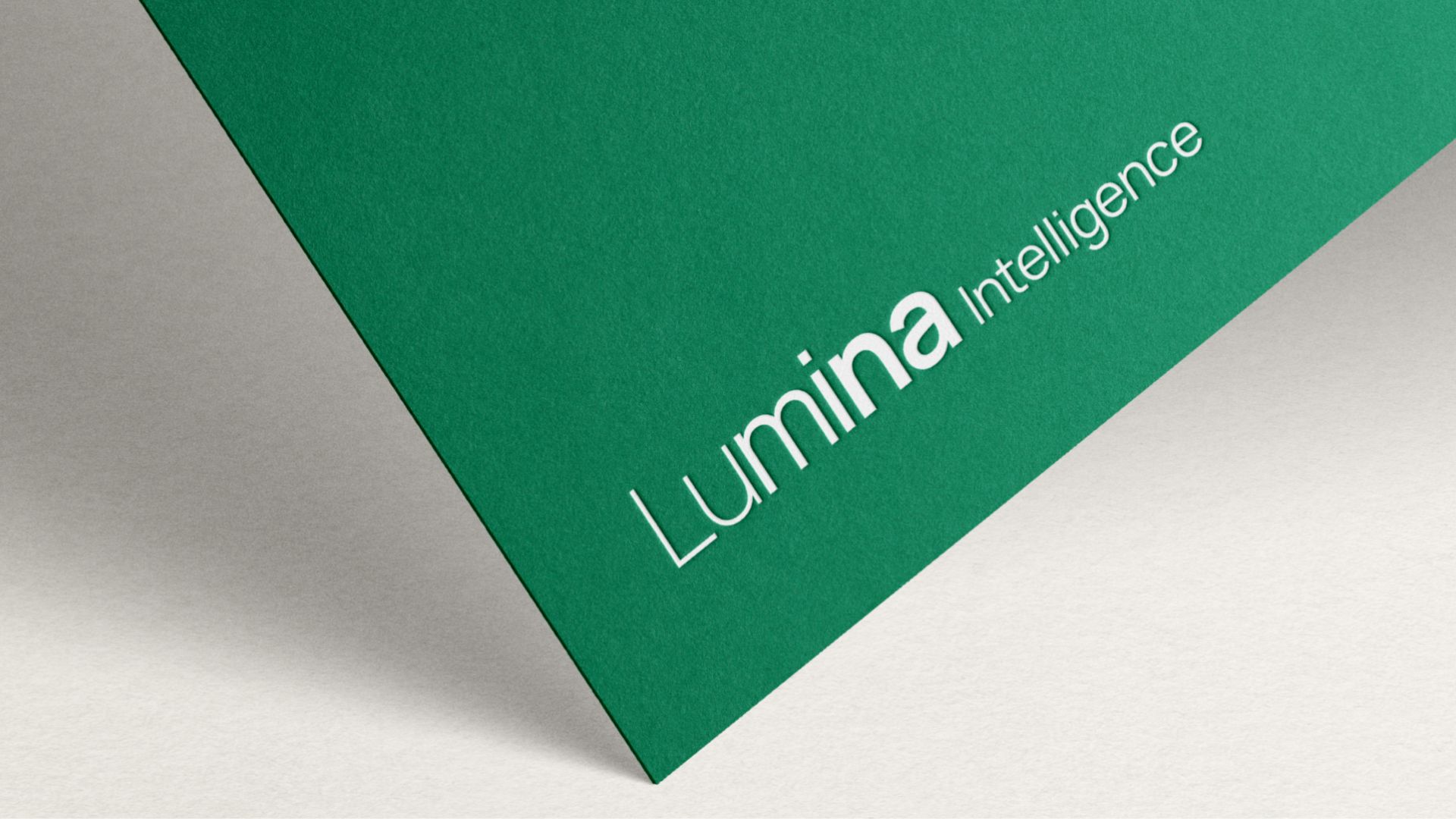 An angled green piece of card with the logo of Lumina Intelligence positioned in the corner